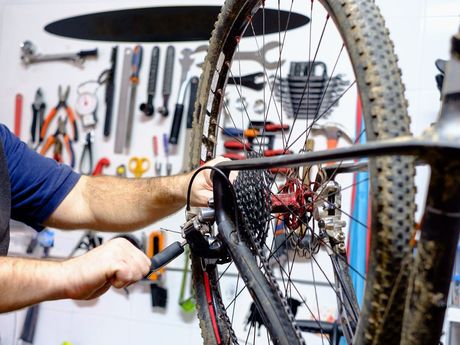Mechaniker, der ein Fahrrad repariert für die Informationsplattform
